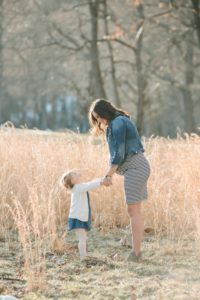 Daughter looking up at Pregnant Mom in field at North Park near Pittsburgh