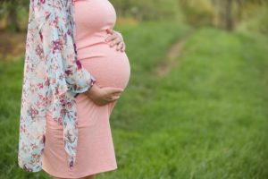 Pregnant woman holding belly at Soergel Orchards near Pittsburgh