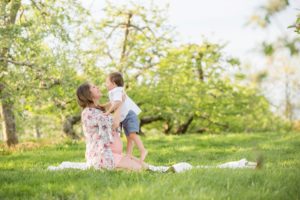 Pregnant woman sitting on ground with son at Soergel Orchards near Pittsburgh