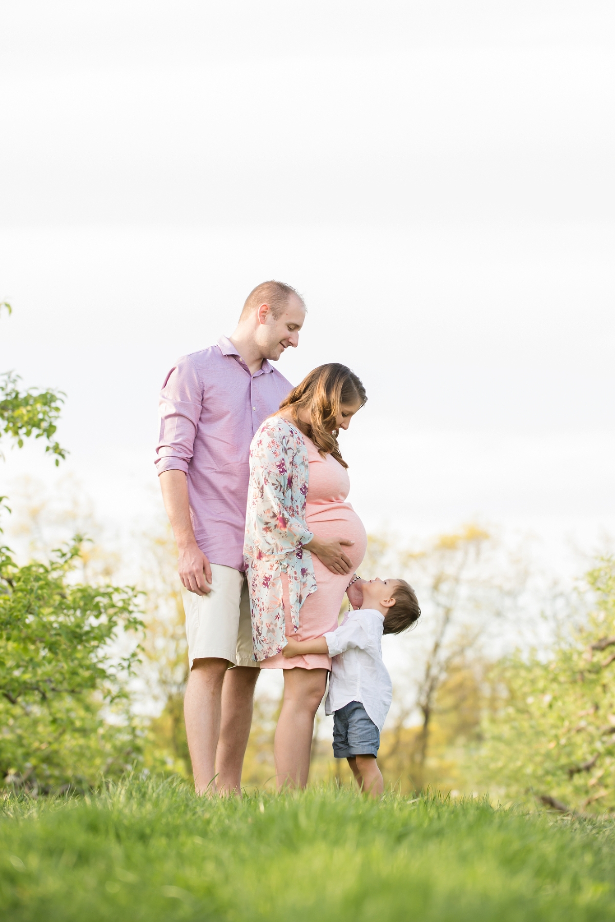 Son looking up at pregnant mom and dad at Soergel Orchards near Pittsburgh