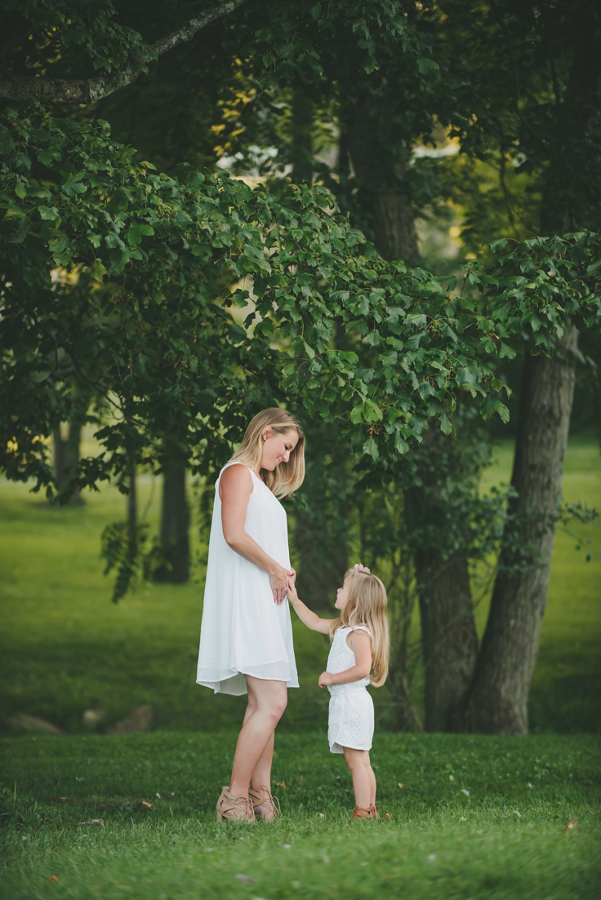 Little girl touching her mom's pregnant belly in Pittsburgh