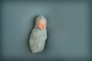 Newborn baby boy laying on blue blanket in the photography studio in Moon Township near Pittsburgh