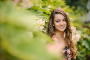 High school senior girl standing next to plant at Mellon Park near Pittsburgh
