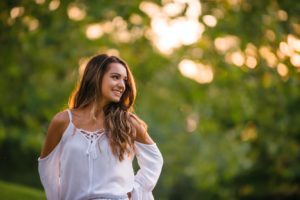 High school senior girl looking over shoulder at Mellon Park near Pittsburgh