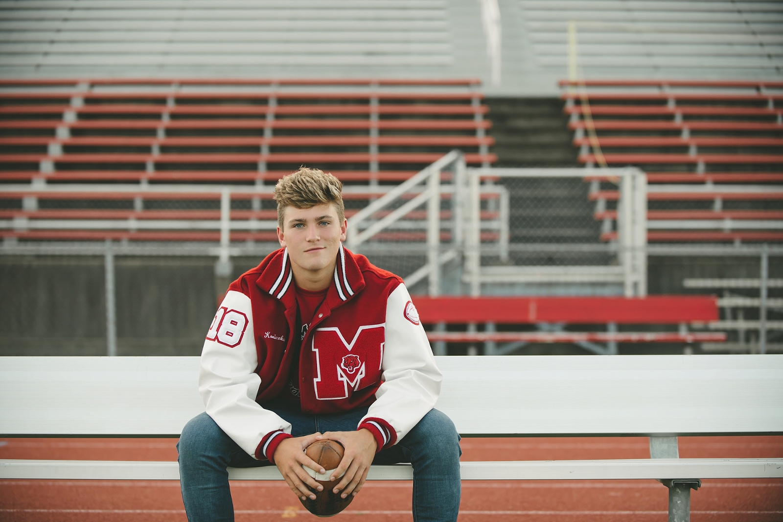 High school senior boy sitting on football field at Moon Area High School near Pittsburgh