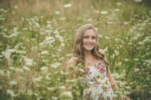 High school senior girl sitting in flowers Sewickley Heights Borough Park near Pittsburgh