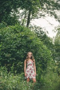 High school senior girl standing next to tree Sewickley Heights Borough Park near Pittsburgh