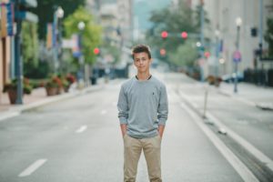 High school senior boy standing in the street in downtown Pittsburgh