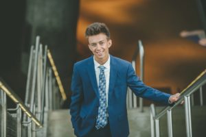 High school senior boy standing on the steps in downtown Pittsburgh