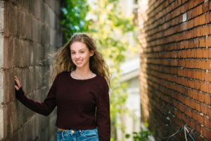 High school senior girl standing next to brick wall in Lawrenceville near Pittsburgh