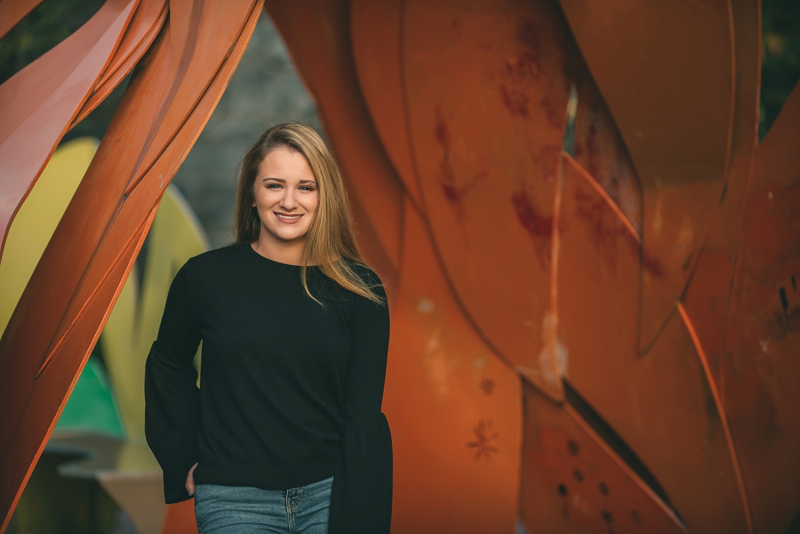High school senior girl standing in front of orange statue in downtown Pittsburgh