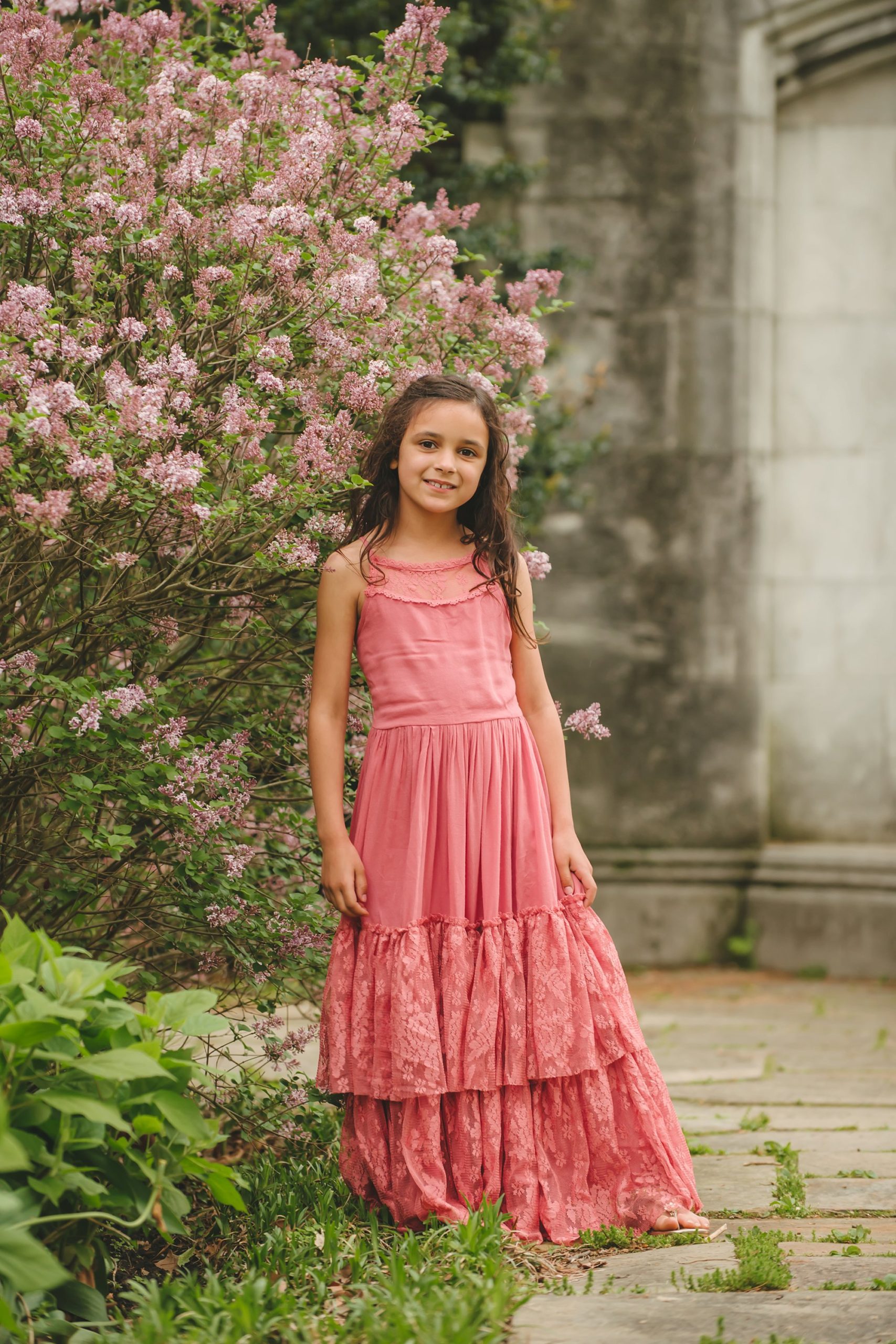 Girl wearing pink dress standing next to flowers in Mellon Park in Pittsburgh