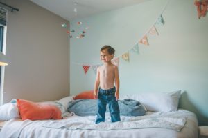 Boy standing on bed in home in Robinson Township near Pittsburgh