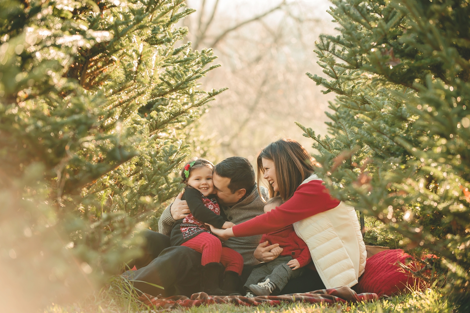 Mom and dad tickling daughter at Nutbrown's Christmas Tree Farm near Pittsburgh