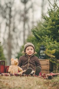 Toddler boy sitting next to bear at Nutbrown's Christmas Tree Farm near Pittsburgh