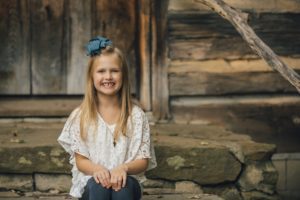 Girl sitting in front of cabin at Robin Hill Park near Pittsburgh