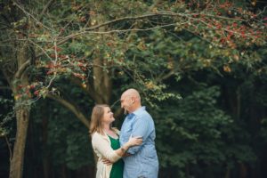 Husband and wife looking at each other in front of tree at Robin Hill Park near PIttsburgh