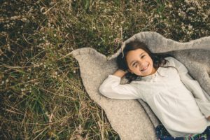 Girl laying on blanket on ground at Sewickley Heights Borough Park near Pittsburgh