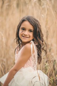 Girl looking over shoulder in field at Sewickley Heights Borough Park near Pittsburgh