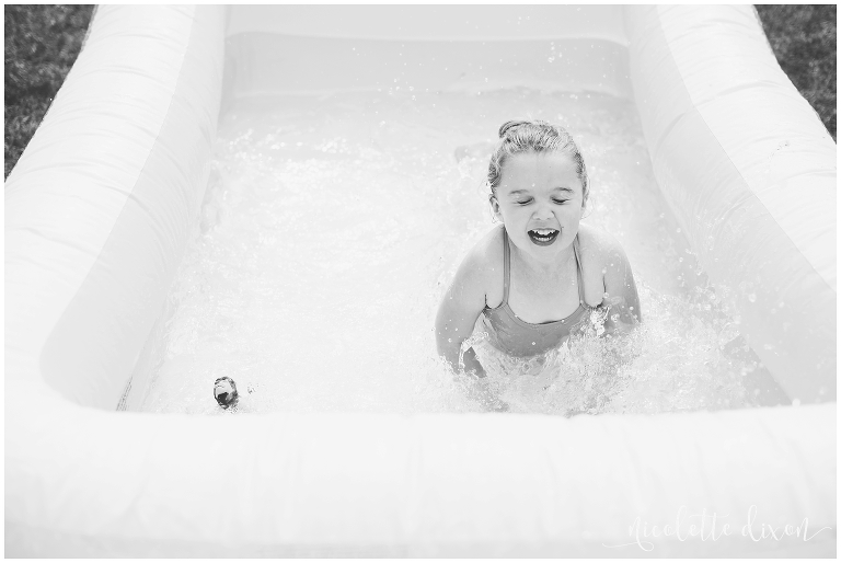 Girl splashing in water in pool at home near Pittsburgh