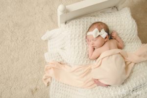 Baby laying on baby bed in home near Pittsburgh