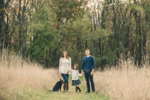 Family standing in field with dog at Sewickley Heights Borough Park near Pittsburgh