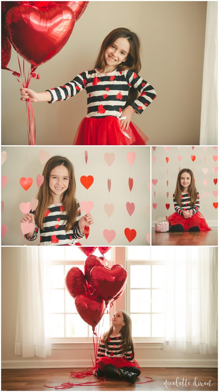 Little girl wearing Valentine's Day dress and holding heart shaped balloons in studio in Moon Township near Pittsburgh