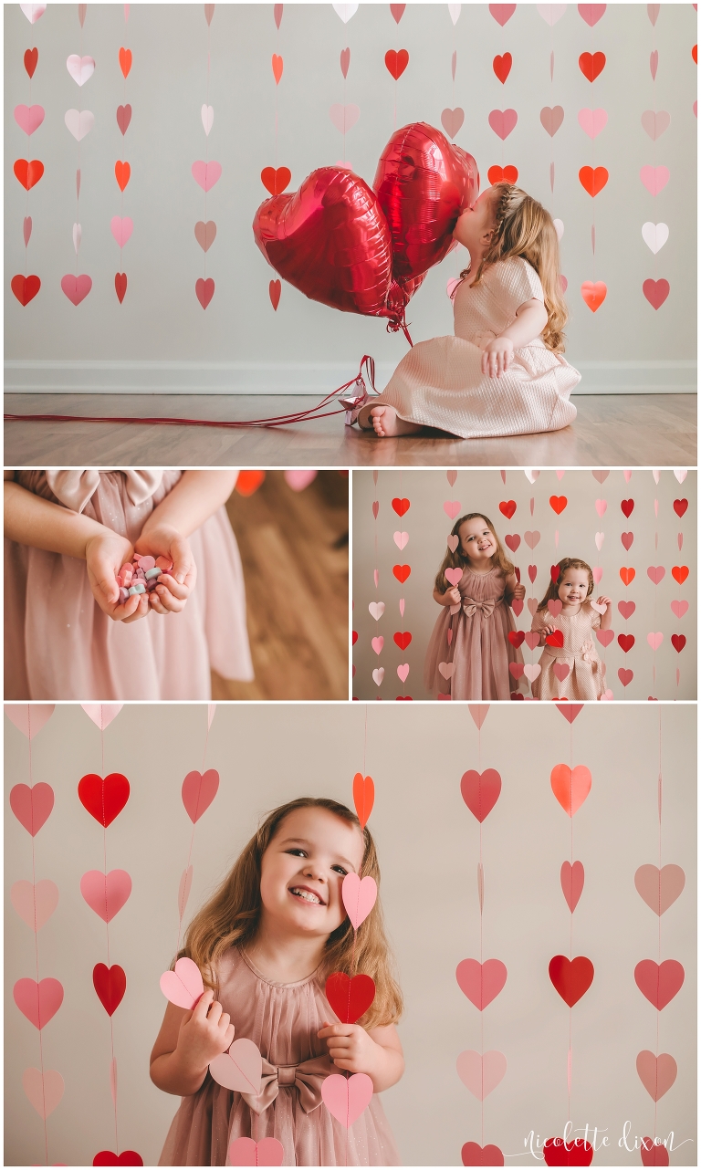 Sisters playing in a photography studio near Pittsburgh with heart shaped garland for Valentine's Day