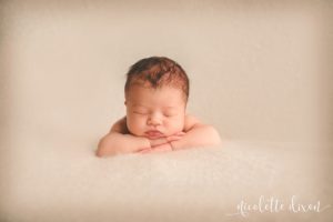 Newborn baby girl laying on light pink blanket in photography studio in Moon Township near Pittsburgh