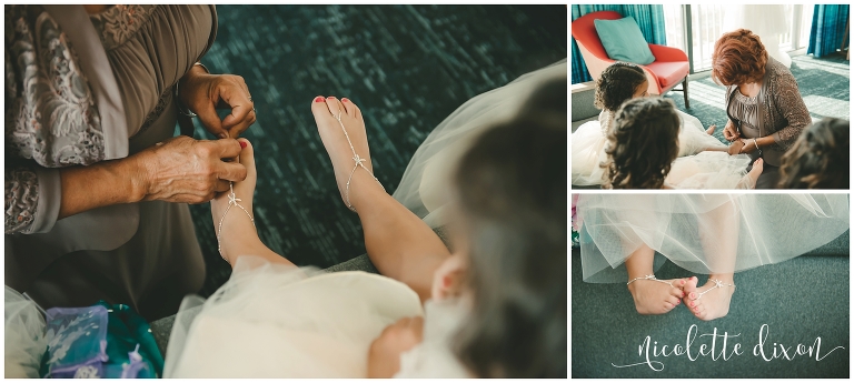 Mother of the groom putting foot jewelry on the flower girls for beach wedding