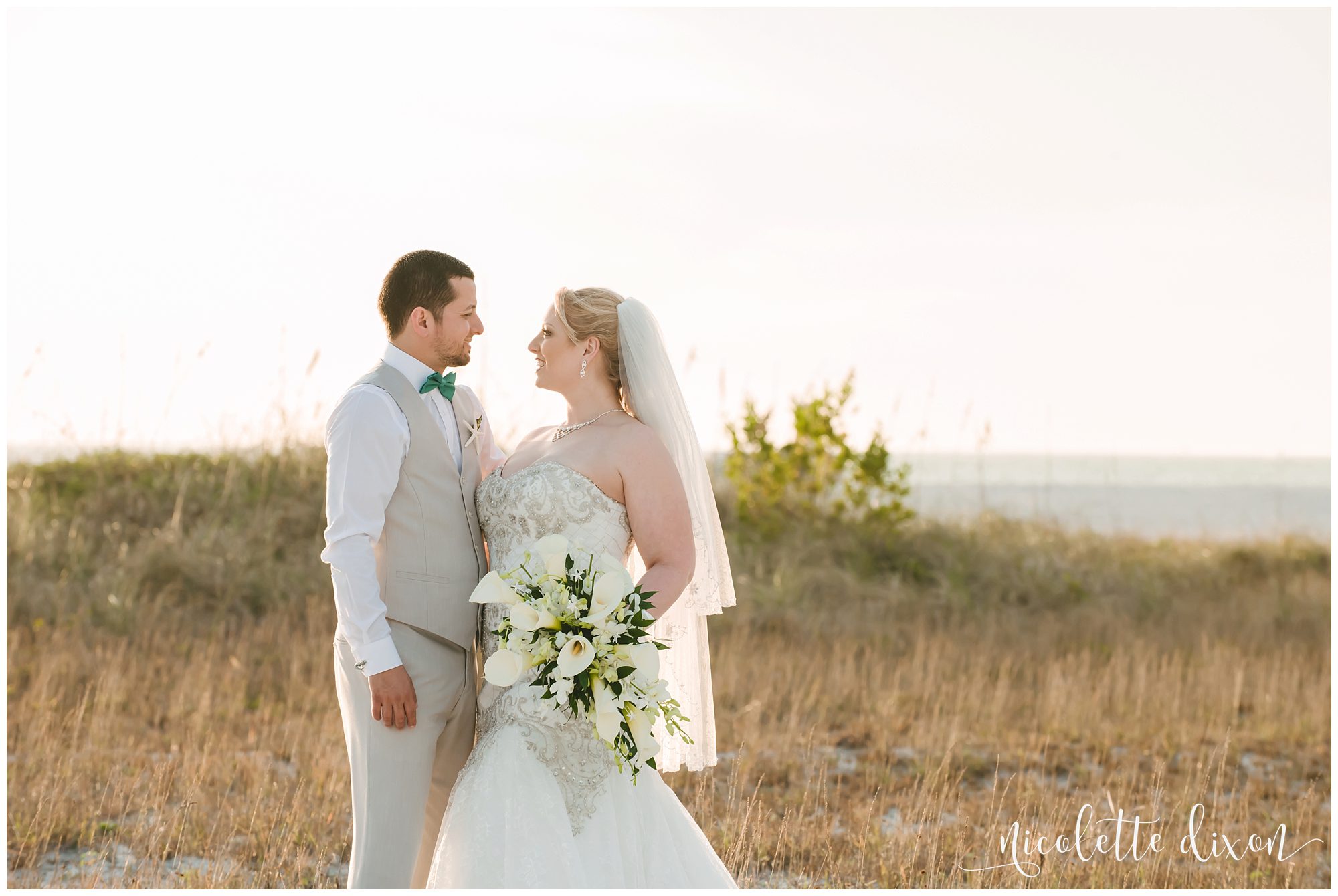 Bride and groom looking at each other at the beach