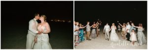 Bride and groom walking under sparklers at beach wedding