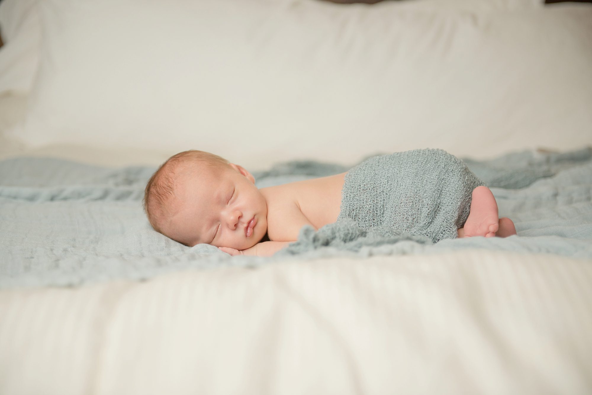 Newborn baby boy laying on bed in home in Moon Township near Pittsburgh