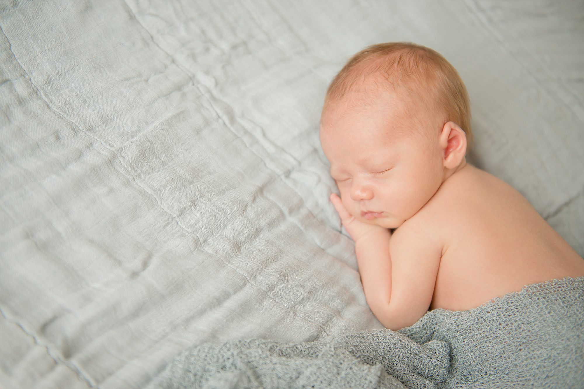 Newborn baby boy laying on blue blanket in home in Moon Township near Pittsburgh