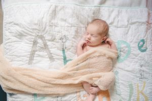 Newborn baby girl laying on alphabet blanket in home in Robinson Township near Pittsburgh