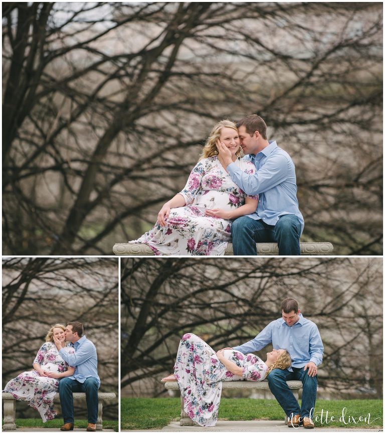 Husband kissing pregnant wife on the cheek on a bench by the Cathedral of Learning at the University of Pittsburgh near Pittsburgh