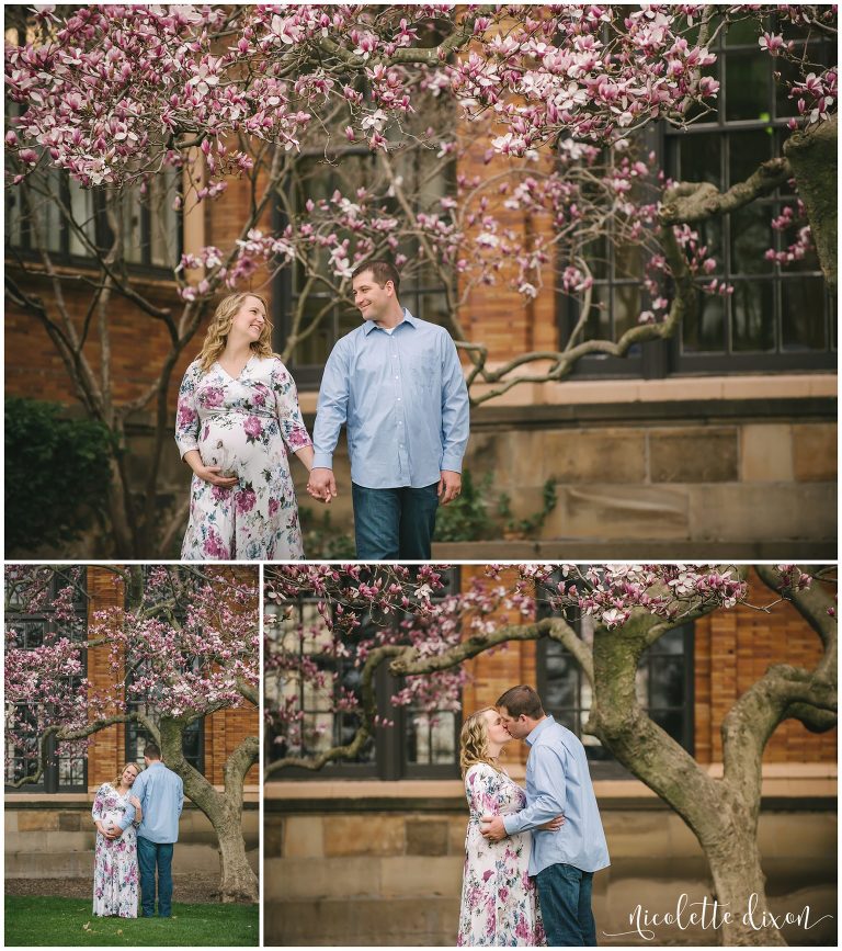 Husband and pregnant wife walking in front of magnolia tree at the University of Pittsburgh near Pittsburgh