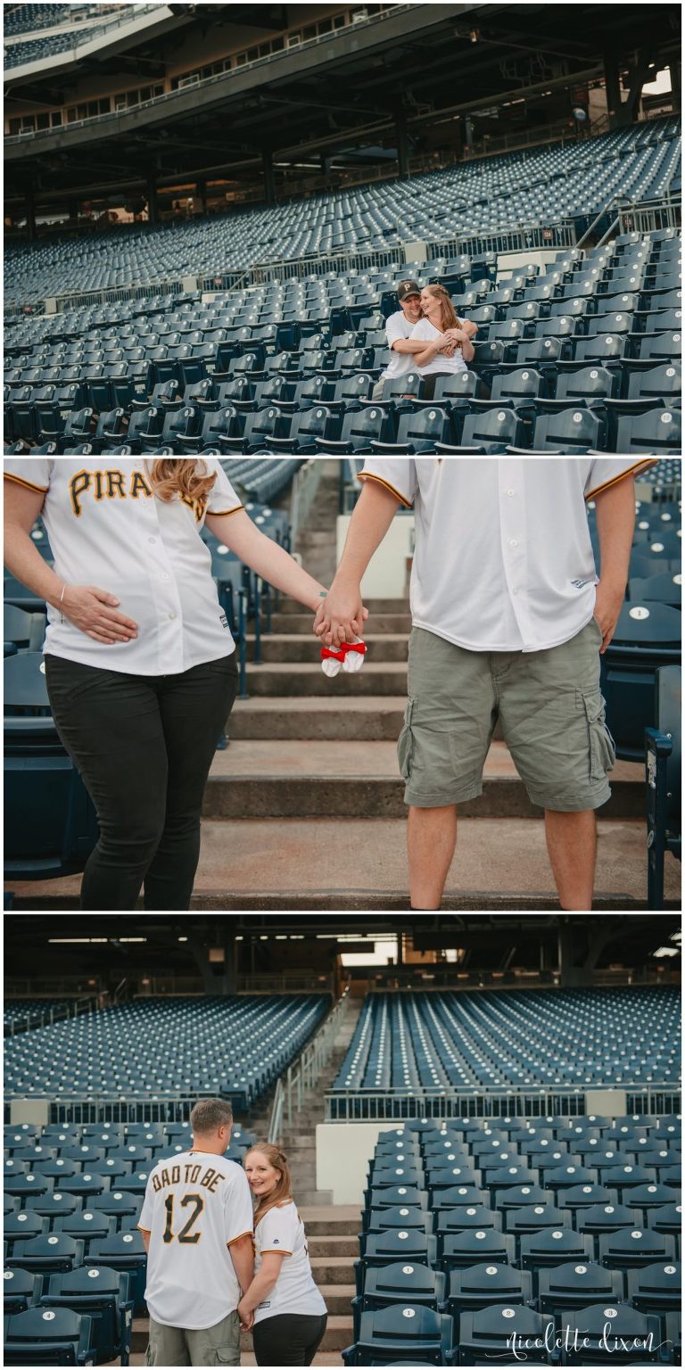 Man and woman holding each other in the stands and holding baby booties at PNC Park near Pittsburgh