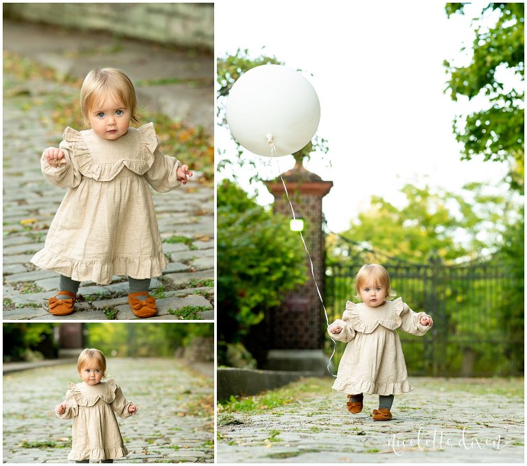 Toddler wearing a cream dress playing with a ballon in Mellon Park near Pittsburgh