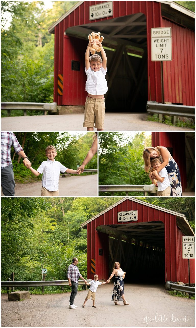 Boy holding bear in front of covered bridge at McConnells Mill State Park near Pittsburgh