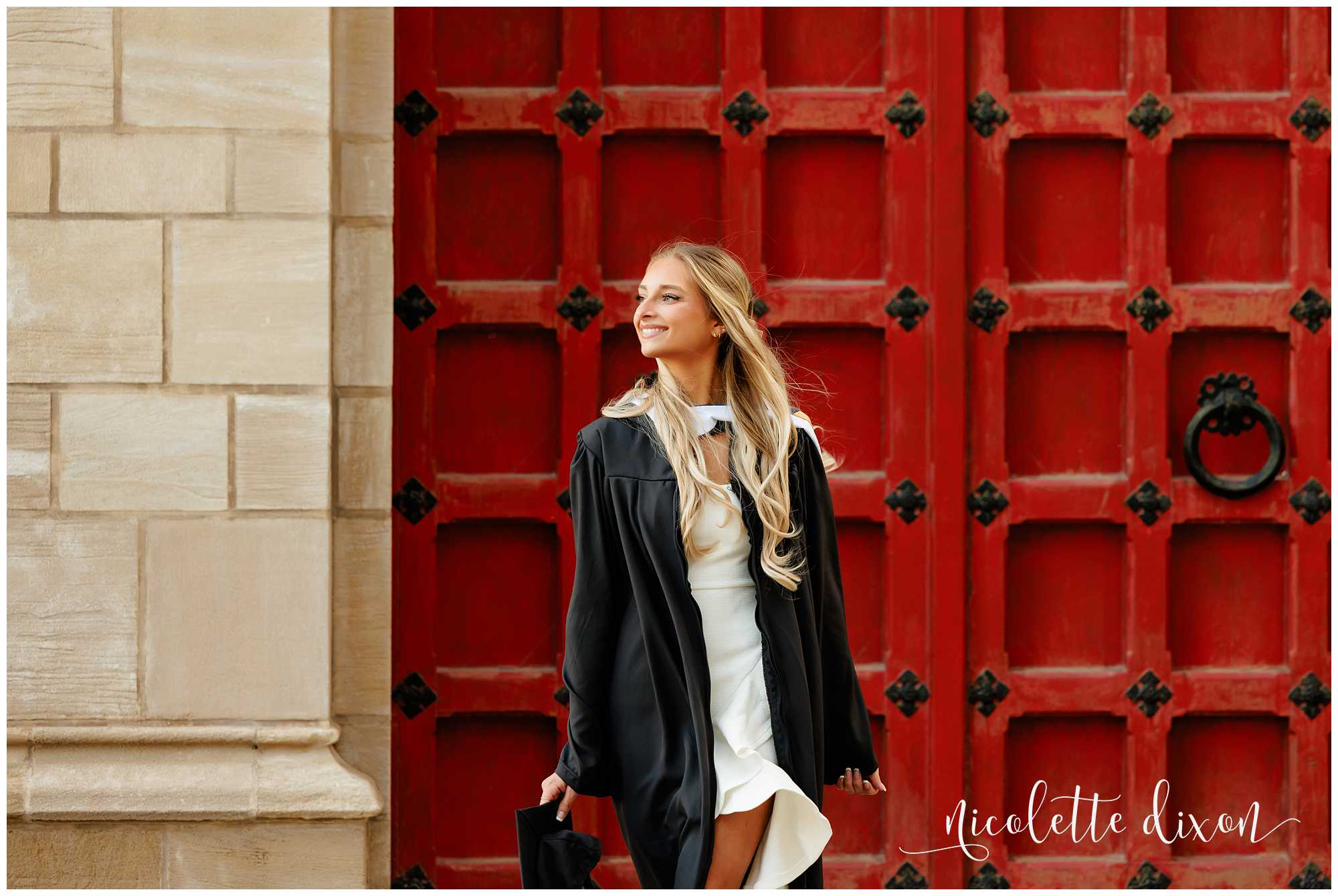 College graduate standing in front of red door at the University of Pittsburgh 