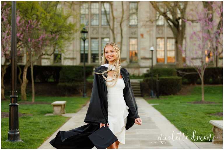 College graduate standing in front of the Cathedral of Learning at the University of Pittsburgh 