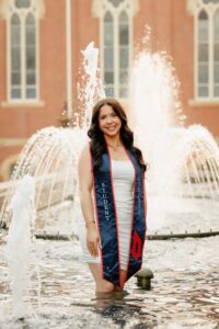College graduate standing in front of fountain at Duquesne University in Pittsburgh