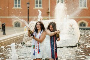 College graduate opening champagne in fountain at Duquesne University in Pittsburgh