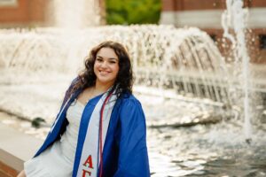 College graduate sitting next to fountain at Duquesne University in Pittsburgh