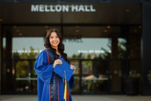 College graduate standing in front of Mellon Hall at Duquesne University in Pittsburgh