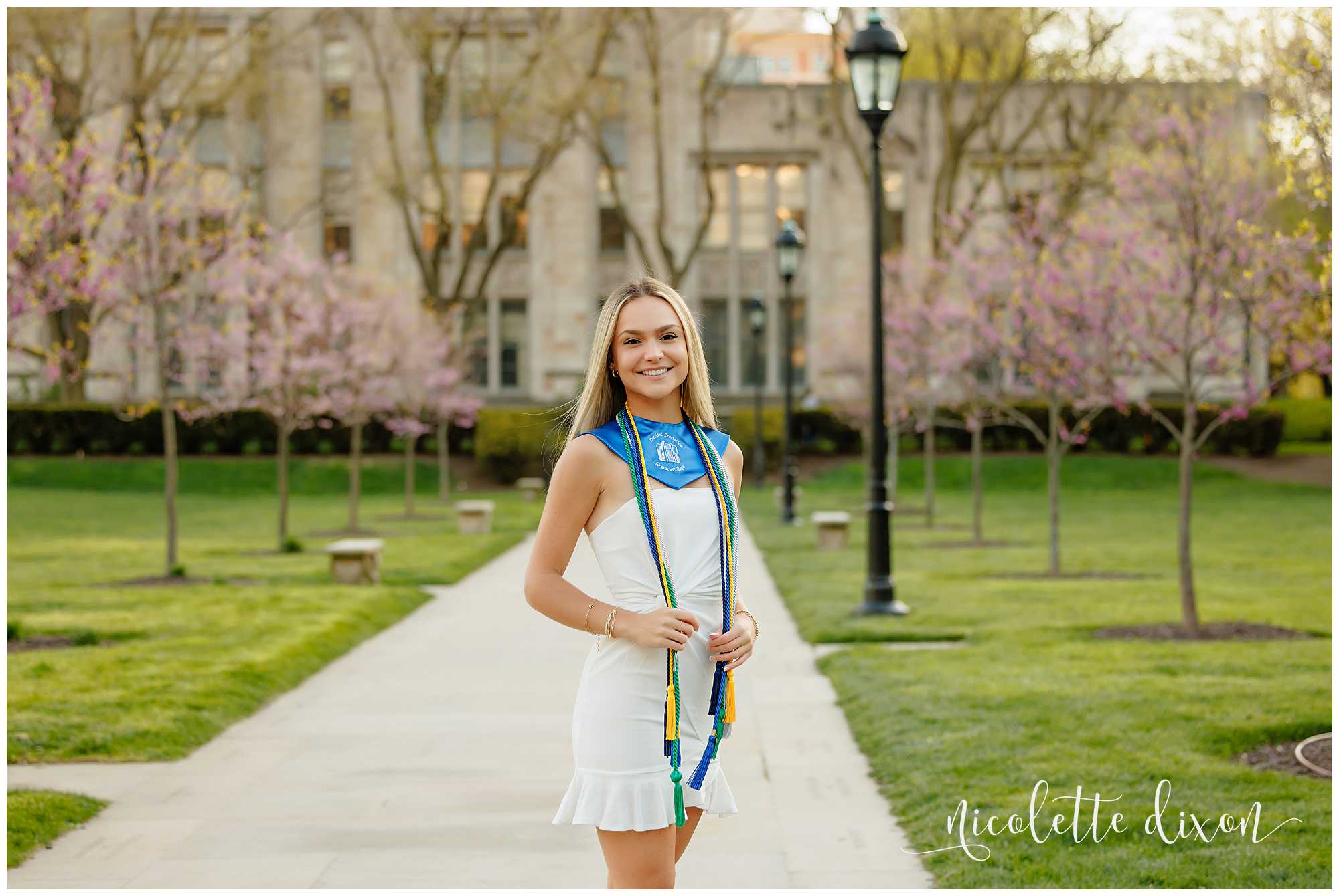 College grad standing in front of the Cathedral of Learning at the University of Pittsburgh