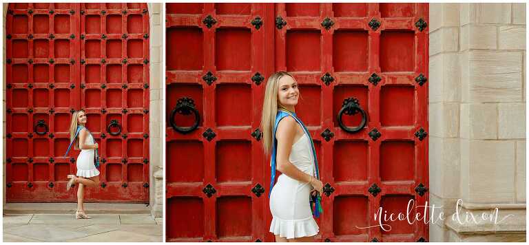 College grad standing in front of the red doors at the Cathedral of Learning at the University of Pittsburgh