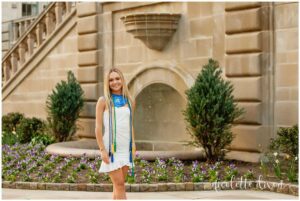 College grad standing in front of the fountain at the Cathedral of Learning at the University of Pittsburgh
