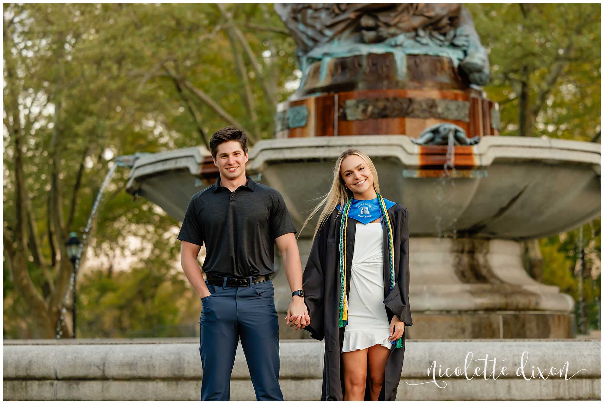 College grad standing with boyfriend in front of the Mary Schenley Memorial Fountain at the University of Pittsburgh